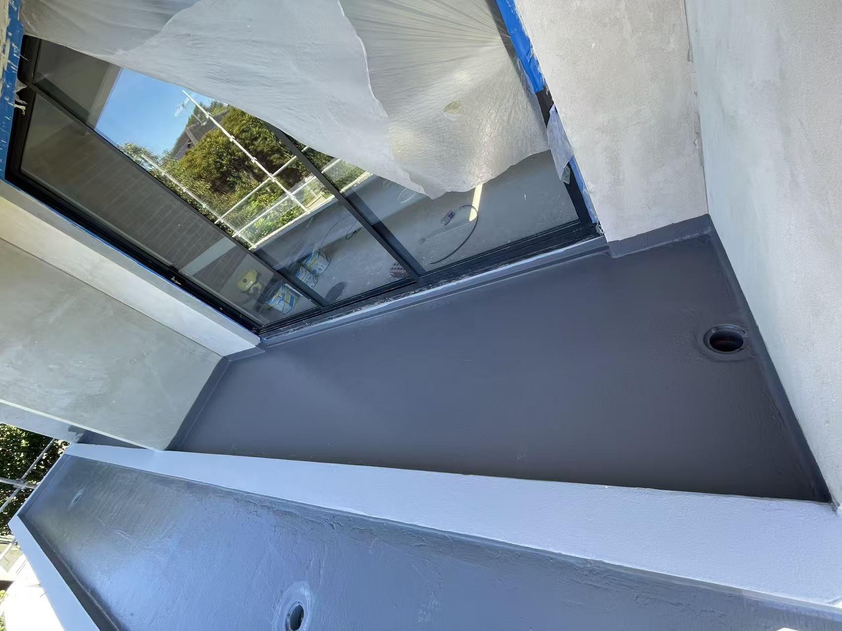 Waterproofing membrane applied across an external balcony surface