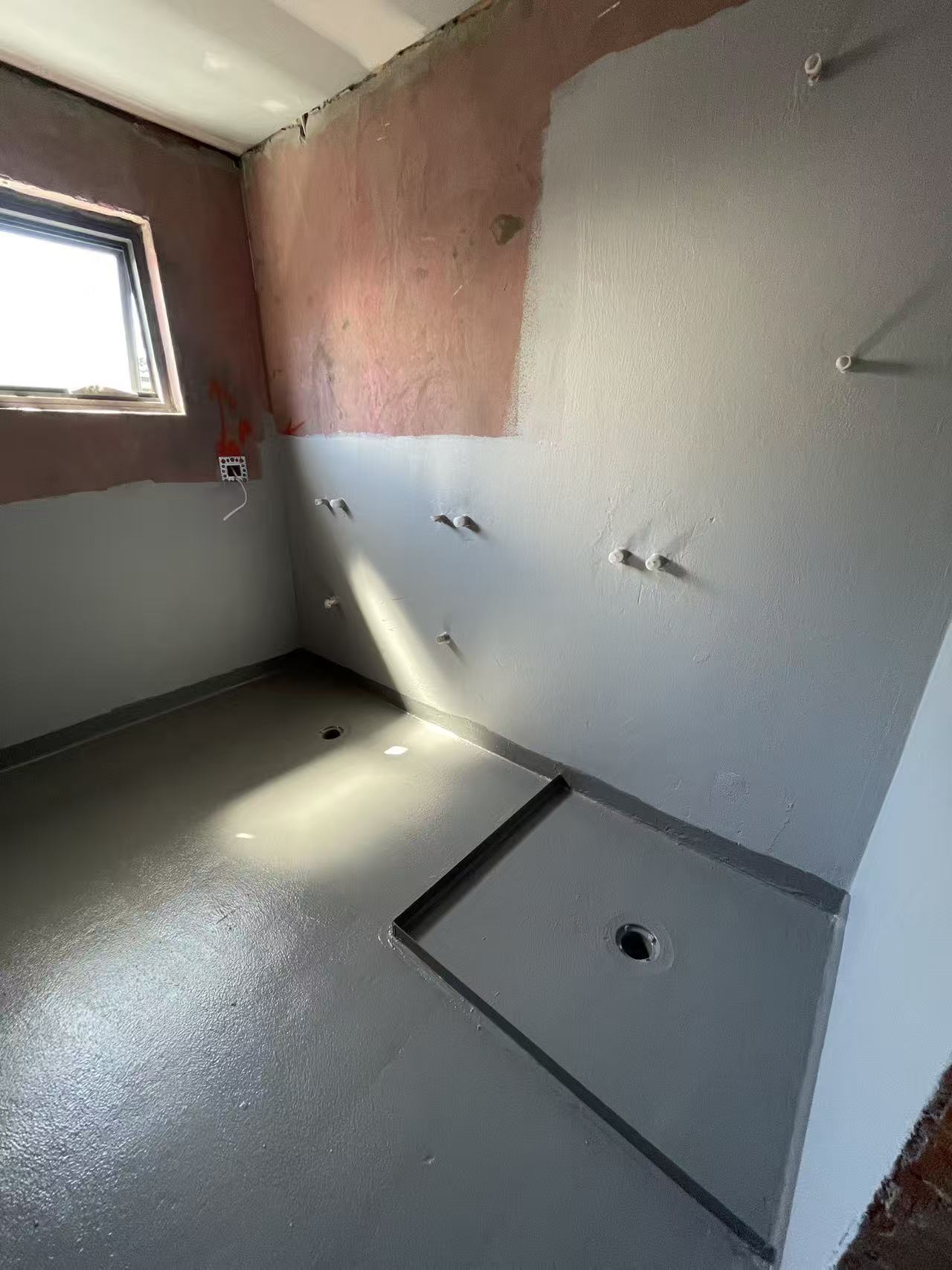Waterproofing membrane applied to a bathroom wet-area floor and wall junctions